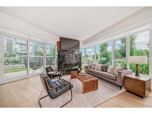 103-128 Waterfront Court Sw, Calgary, AB - Indoor Photo Showing Living Room With Fireplace