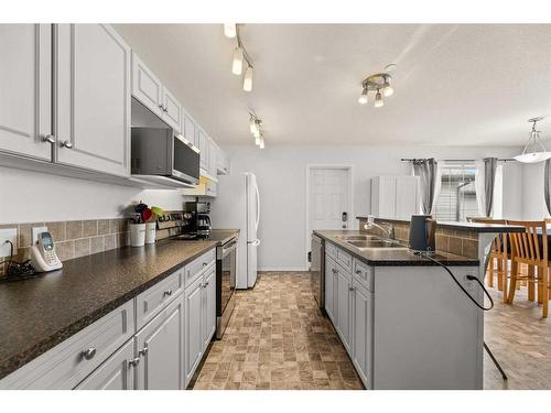 12 Mackenzie Way, Carstairs, AB - Indoor Photo Showing Kitchen With Double Sink