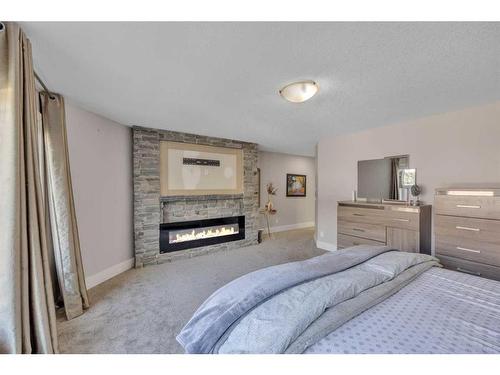 177 Stonemere Close, Chestermere, AB - Indoor Photo Showing Bedroom With Fireplace