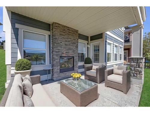 28 Sunset Manor, Cochrane, AB - Outdoor With Fireplace With Deck Patio Veranda