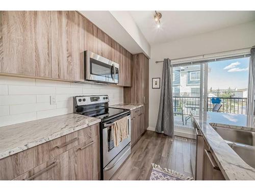 2409 Jumping Pound Common, Cochrane, AB - Indoor Photo Showing Kitchen With Double Sink With Upgraded Kitchen