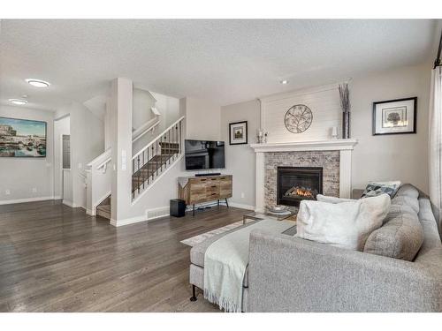 83 Sundown Way, Cochrane, AB - Indoor Photo Showing Living Room With Fireplace