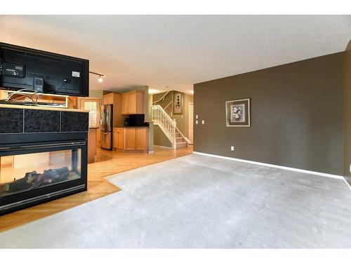 55 Bridlepost Green Sw, Calgary, AB - Indoor Photo Showing Living Room With Fireplace