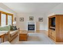 119 Oakside Place Sw, Calgary, AB  - Indoor Photo Showing Living Room With Fireplace 