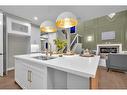 335 Waterford Grove, Chestermere, AB  - Indoor Photo Showing Kitchen With Fireplace With Double Sink 