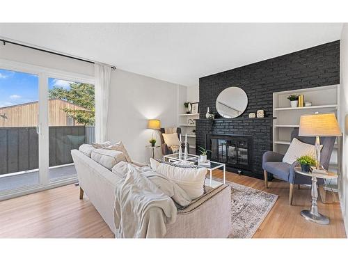 104-9803 24 Street Sw, Calgary, AB - Indoor Photo Showing Living Room With Fireplace