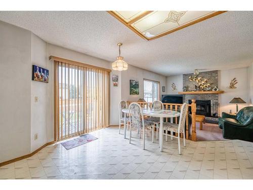 223 Coventry Close Ne, Calgary, AB - Indoor Photo Showing Dining Room With Fireplace