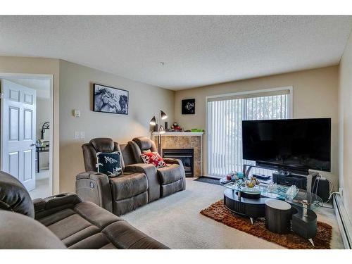 3308-10 Prestwick Bay Se, Calgary, AB - Indoor Photo Showing Living Room With Fireplace