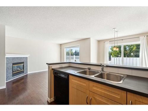 73 Rocky Ridge Heath Nw, Calgary, AB - Indoor Photo Showing Kitchen With Fireplace With Double Sink