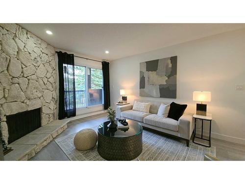 203-1001 68 Avenue Sw, Calgary, AB - Indoor Photo Showing Living Room With Fireplace