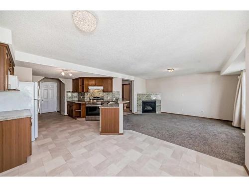 184 Bridlewood Road Sw, Calgary, AB - Indoor Photo Showing Kitchen With Fireplace