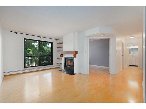 309-2611 1 Avenue Nw, Calgary, AB - Indoor Photo Showing Living Room With Fireplace