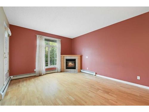 210-5201 Dalhousie Drive Nw, Calgary, AB - Indoor Photo Showing Living Room With Fireplace