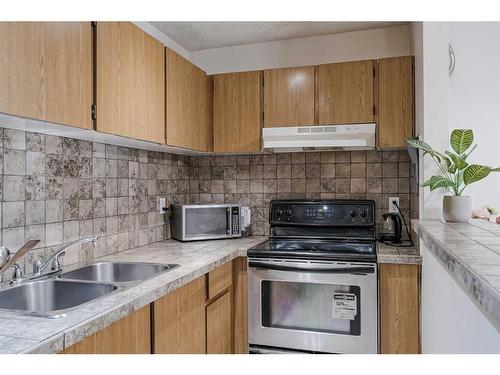 109-1712 38 Street Se, Calgary, AB - Indoor Photo Showing Kitchen With Double Sink