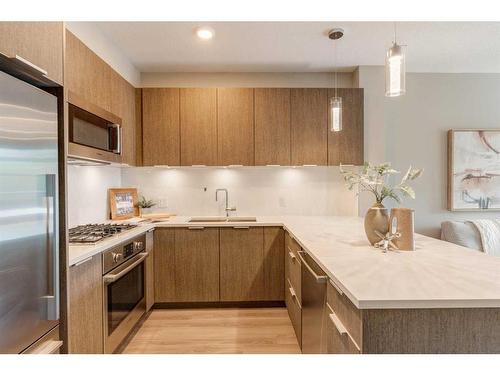 207-823 5 Avenue Nw, Calgary, AB - Indoor Photo Showing Kitchen With Stainless Steel Kitchen With Double Sink With Upgraded Kitchen