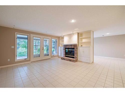 36 Sunrise Way, Priddis Greens, AB - Indoor Photo Showing Other Room With Fireplace