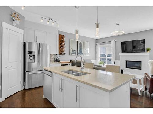 288 Rainbow Falls Green, Chestermere, AB - Indoor Photo Showing Kitchen With Fireplace With Double Sink With Upgraded Kitchen