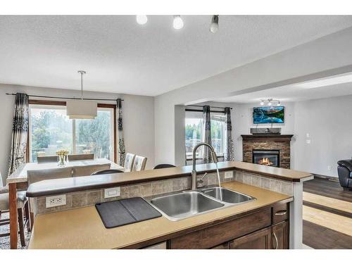 105 Aspenmere Place, Chestermere, AB - Indoor Photo Showing Kitchen With Fireplace With Double Sink