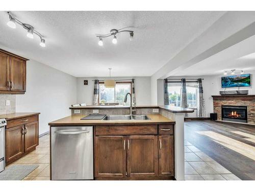 105 Aspenmere Place, Chestermere, AB - Indoor Photo Showing Kitchen With Fireplace With Double Sink