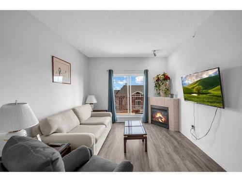 1304-70 Panamount Drive Nw, Calgary, AB - Indoor Photo Showing Living Room With Fireplace