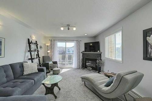 1212-7451 Springbank Boulevard Sw, Calgary, AB - Indoor Photo Showing Living Room With Fireplace