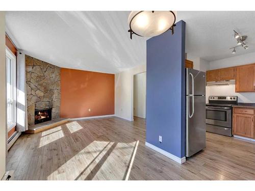 105-205 5 Avenue Ne, Calgary, AB - Indoor Photo Showing Kitchen With Fireplace