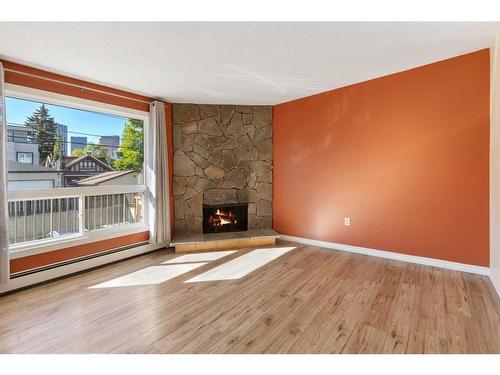 105-205 5 Avenue Ne, Calgary, AB - Indoor Photo Showing Living Room With Fireplace