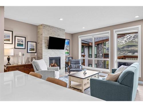 310-106 Stewart Creek Rise, Canmore, AB - Indoor Photo Showing Living Room With Fireplace