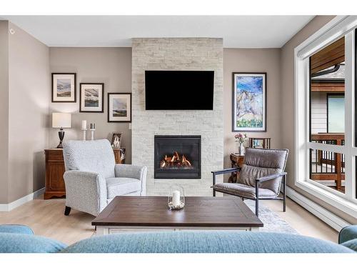 310-106 Stewart Creek Rise, Canmore, AB - Indoor Photo Showing Living Room With Fireplace