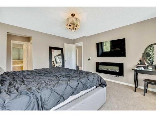 771 Windridge Road Sw, Airdrie, AB - Indoor Photo Showing Bedroom With Fireplace