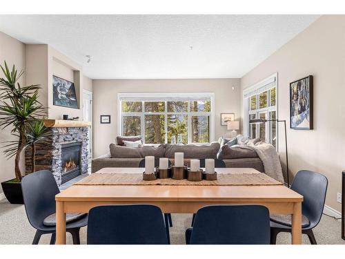 102-3 Aspen Glen, Canmore, AB - Indoor Photo Showing Dining Room With Fireplace