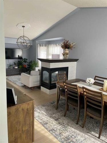 65 Shawnee Crescent Sw, Calgary, AB - Indoor Photo Showing Dining Room With Fireplace