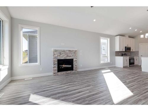 20 Country Meadows Cove, Diamond Valley, AB - Indoor Photo Showing Living Room With Fireplace