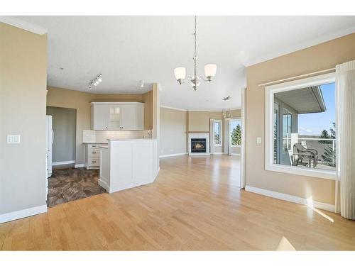 308-200 Patina Court Sw, Calgary, AB - Indoor Photo Showing Kitchen With Fireplace