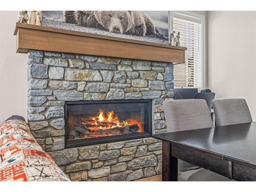 201G-1101 Three Sisters Parkway, Canmore, AB - Indoor Photo Showing Living Room With Fireplace