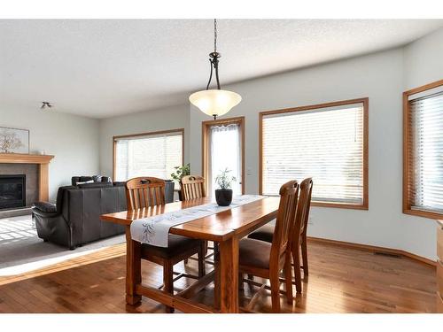 126 West Pointe Court, Cochrane, AB - Indoor Photo Showing Dining Room With Fireplace