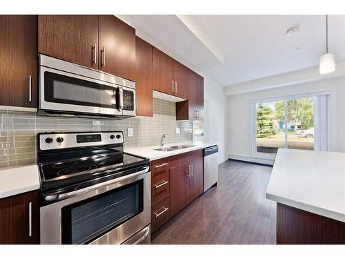 103-15233 1 Street Se, Calgary, AB - Indoor Photo Showing Kitchen With Stainless Steel Kitchen With Double Sink With Upgraded Kitchen