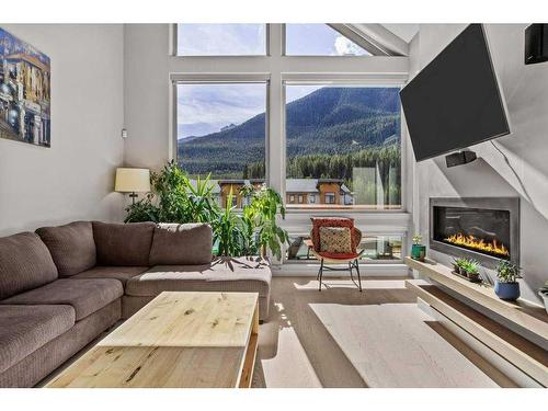 502-105 Stewart Creek Rise, Canmore, AB - Indoor Photo Showing Living Room With Fireplace