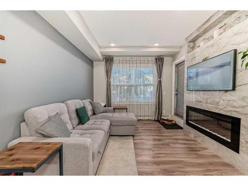 102-19661 40 Street Se, Calgary, AB - Indoor Photo Showing Living Room With Fireplace