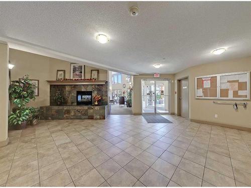 320-428 Chaparral Ravine View Se, Calgary, AB - Indoor Photo Showing Other Room With Fireplace