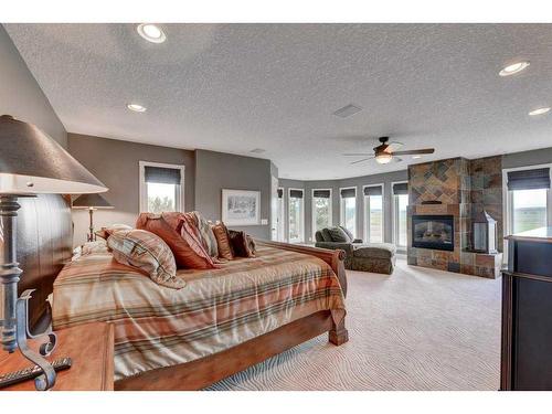 15 Vantage Ridge Estates, Rural Rocky View County, AB - Indoor Photo Showing Bedroom With Fireplace