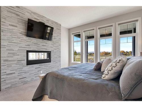 162 Ranch Road, Okotoks, AB - Indoor Photo Showing Bedroom With Fireplace