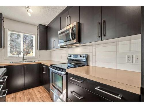 103 Aspen Hills Drive Sw, Calgary, AB - Indoor Photo Showing Kitchen With Stainless Steel Kitchen With Double Sink With Upgraded Kitchen