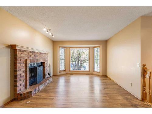 71 Quigley Drive, Cochrane, AB - Indoor Photo Showing Living Room With Fireplace