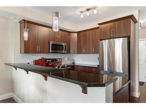 2110-15 Sunset Square, Cochrane, AB - Indoor Photo Showing Kitchen With Stainless Steel Kitchen