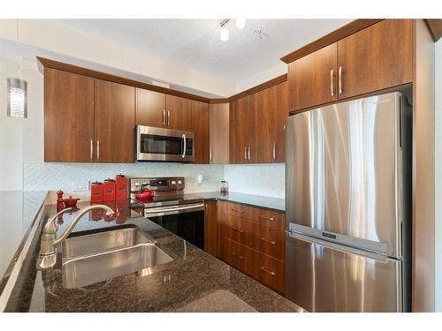 2110-15 Sunset Square, Cochrane, AB - Indoor Photo Showing Kitchen With Stainless Steel Kitchen With Double Sink