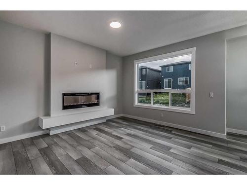 157 Belmont Villas Sw, Calgary, AB - Indoor Photo Showing Living Room With Fireplace