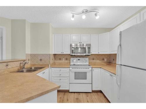 8317-304 Mackenzie Way Sw, Airdrie, AB - Indoor Photo Showing Kitchen With Double Sink