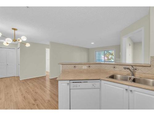 8317-304 Mackenzie Way Sw, Airdrie, AB - Indoor Photo Showing Kitchen With Double Sink