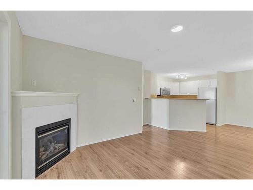 8317-304 Mackenzie Way Sw, Airdrie, AB - Indoor Photo Showing Living Room With Fireplace